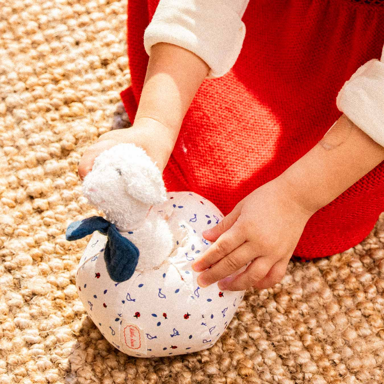 Weiß-blau gemusterte LUISA Lamm Rassel aus nachhaltigem, schadstofffreiem Material, kindgerecht und säuglingstauglich mit.